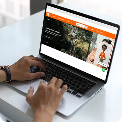 Fotografia de mesa com notebook em destaque. Na tela, o Plugin da Hand Talk funcionando no site do Itaú.