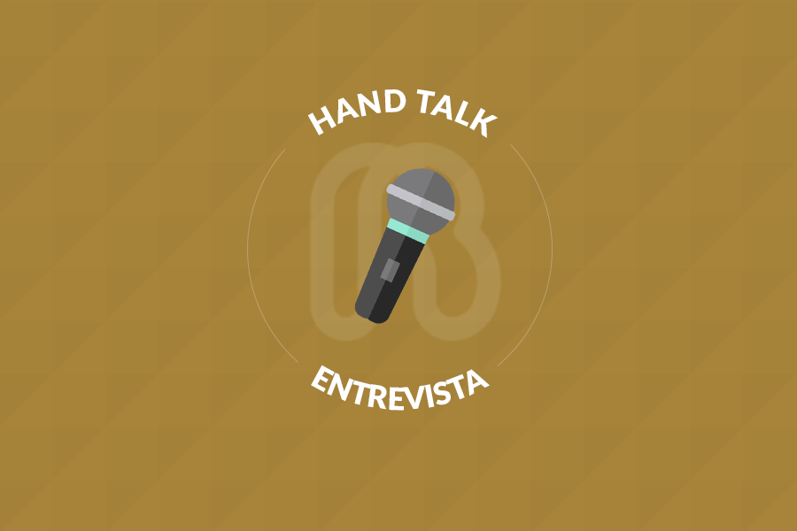 Microfone desenhado no centro. Acima lê-se "Hand Talk" e abaixo "Entrevista". Por trás do microfone há o logo das Faculdades Rio Branco. O fundo da imagem é marrom.