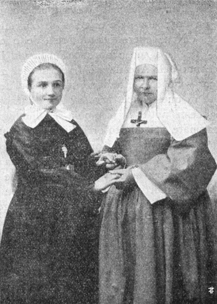 Black and white photo. Maria is next to Margueritte. Both are standing, wearing period clothing.