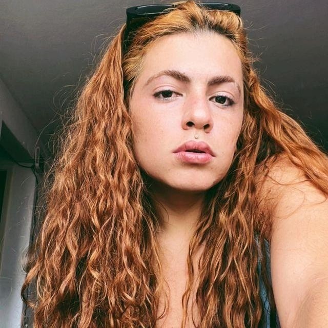 Fotografia de Safira. Ela é uma mulher de pele branca, e cabelos ruivos longos.